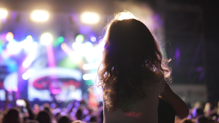 daddy and daughter at a concert, daughter on father's shoulders.