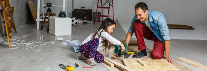 father and daughter doing house repairs in the garage