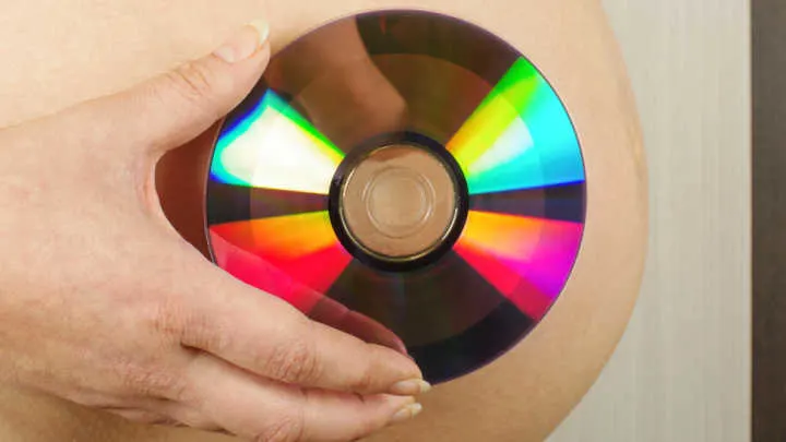 rainbow baby pregnancy announcement with a CD
