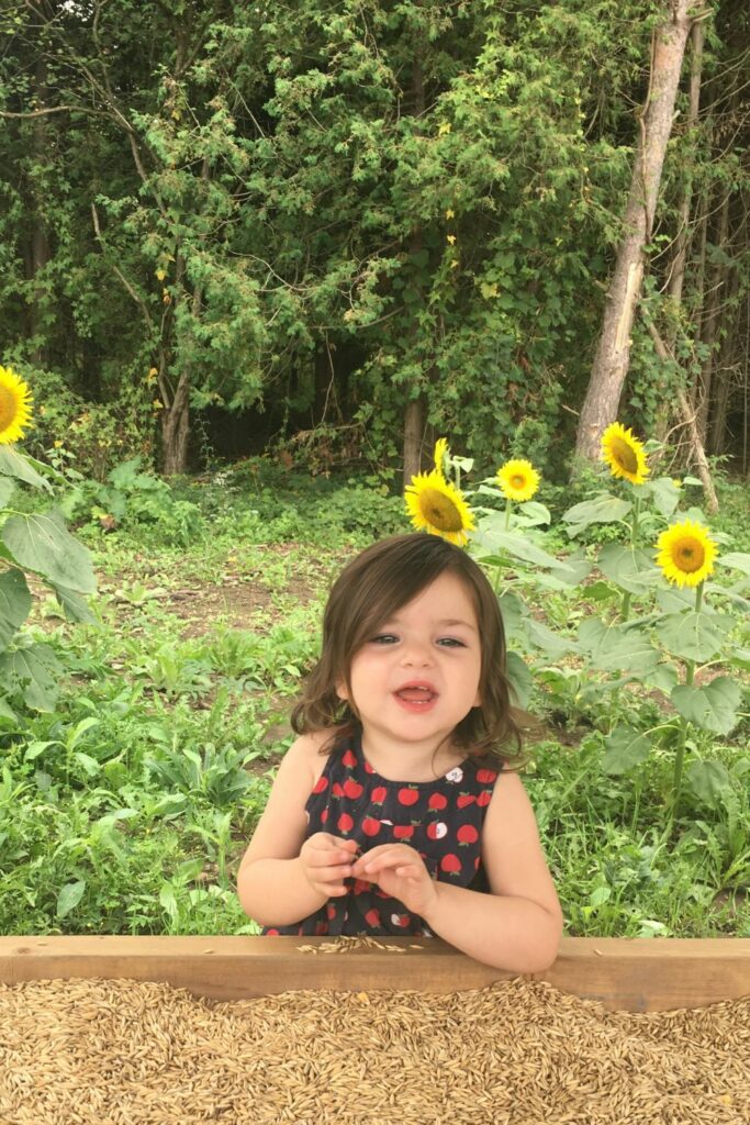 a baby with sunflowers