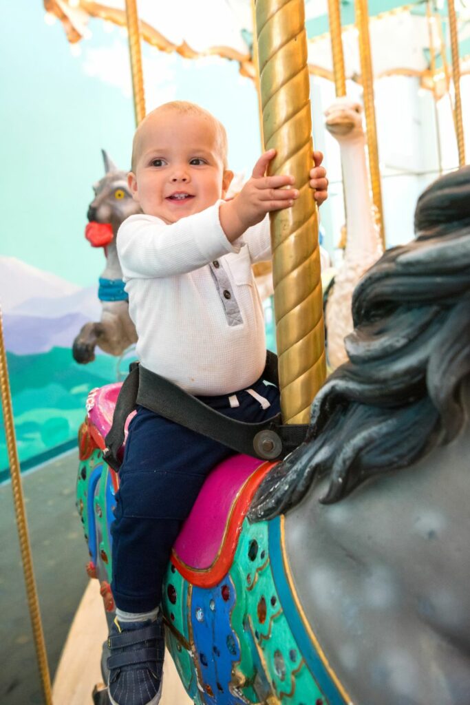 baby riding a carousel